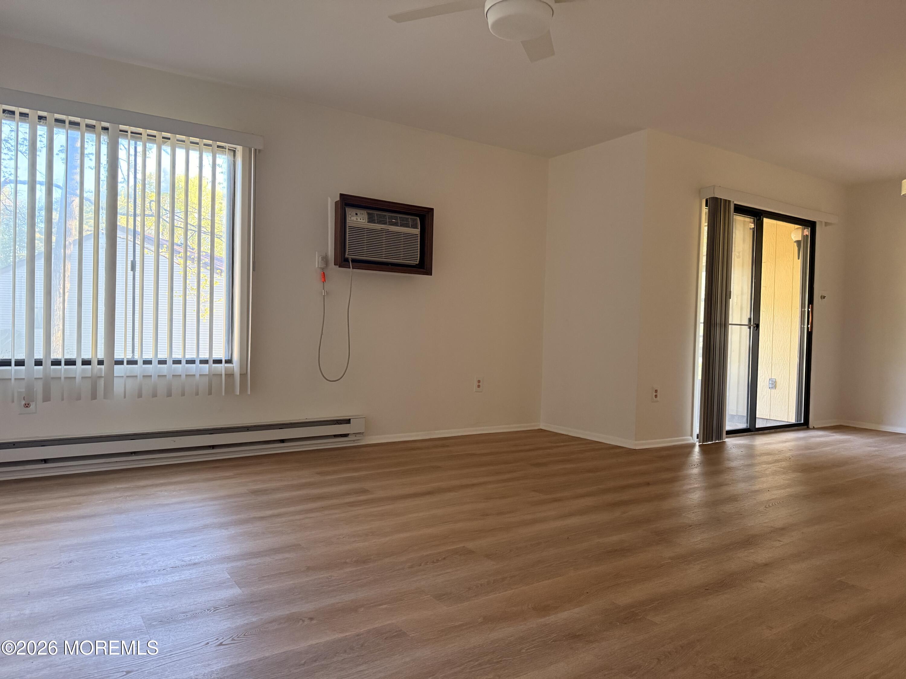 79 Overlook Way, Unit D Manalapan, NJ 07726 - Photo 5 of 13 an empty room with wooden floor and windows