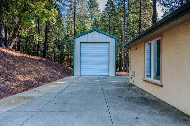 a view of a house with a yard and a large tree