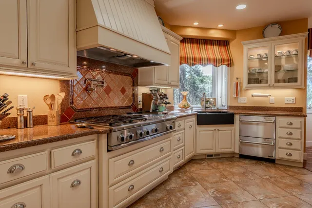 a kitchen with stainless steel appliances granite countertop a stove and a sink