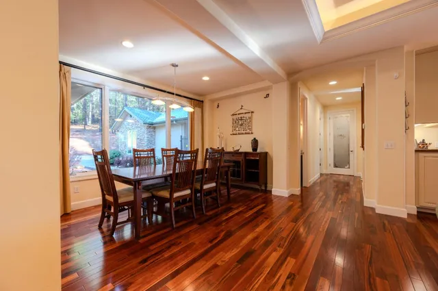 a living room with furniture a dining table and chairs with wooden floor