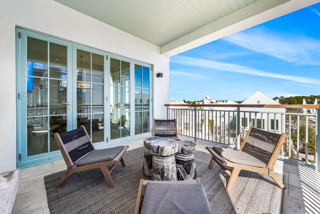 a balcony with chairs and city view