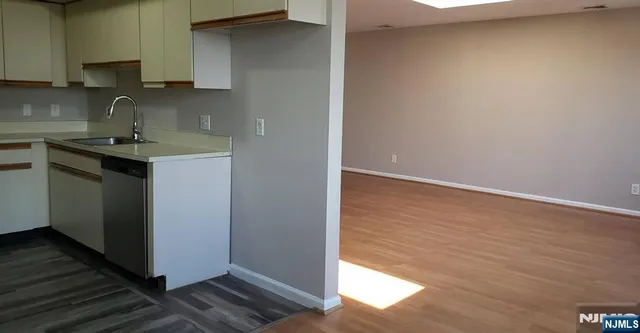 a kitchen with a sink cabinets and a wooden floor