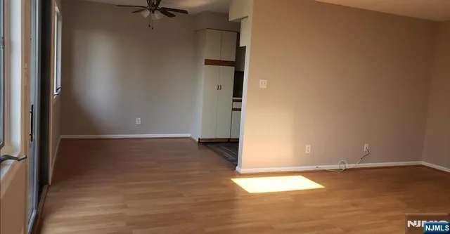 an empty room with wooden floor and a window