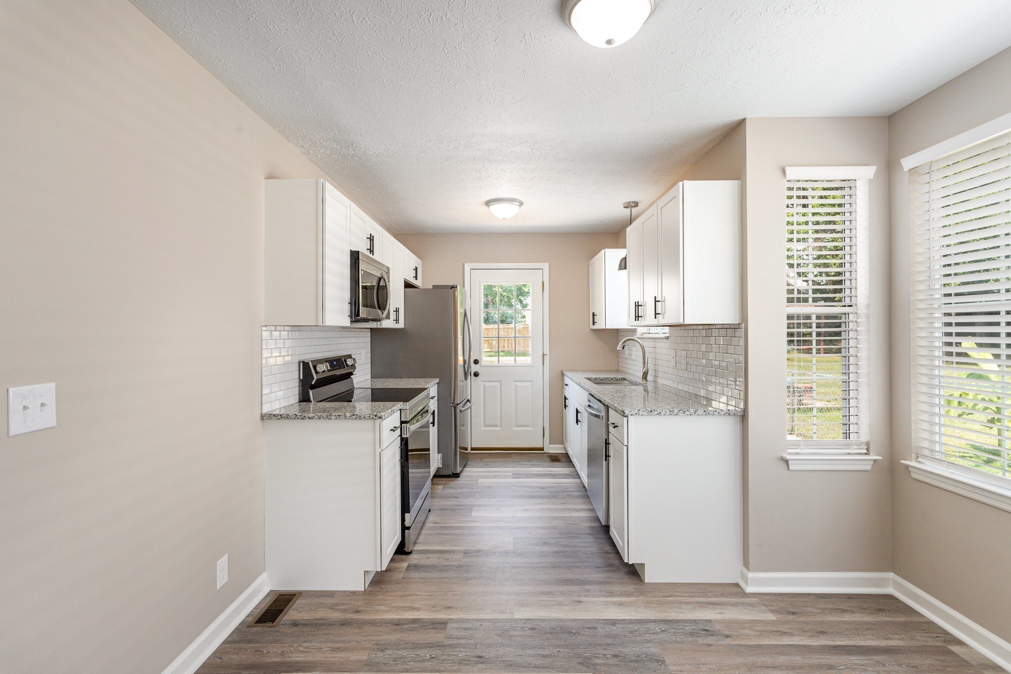 217 Maple Street Madison, TN 37115 - Photo 9 of 44 a kitchen with white cabinets and wooden floor