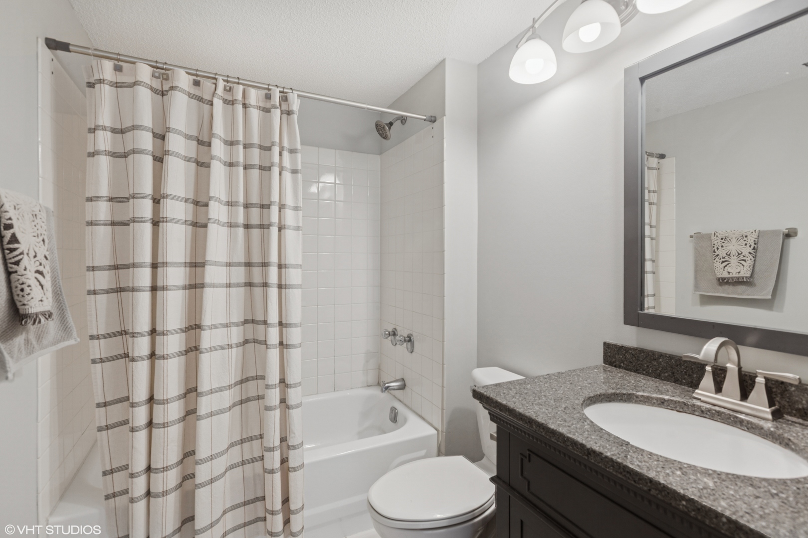 511 Aurora Avenue, Unit 108 Naperville, IL 60540 - Photo 15 of 32 a bathroom with a granite countertop sink toilet a shower and a mirror