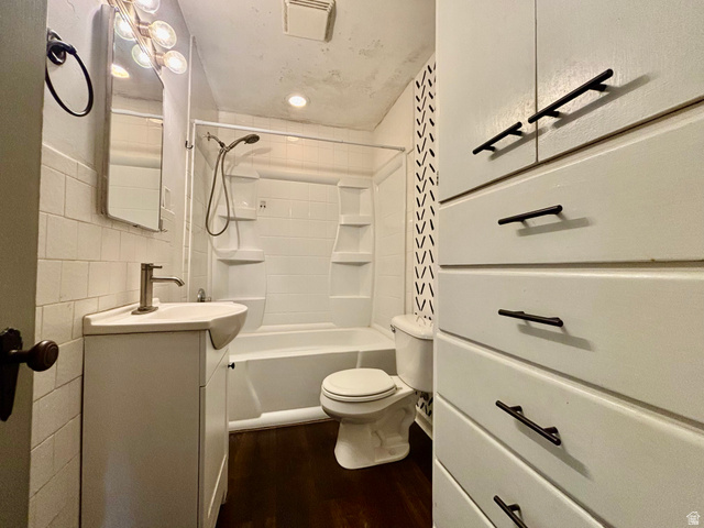 704 North 200 East Logan, UT 84321 - Photo 12 of 24 Bathroom with vanity, dark wood-style flooring, shower / bath combination, and tile walls