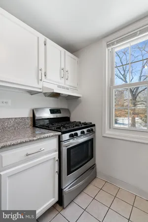 a kitchen with white cabinets and appliances