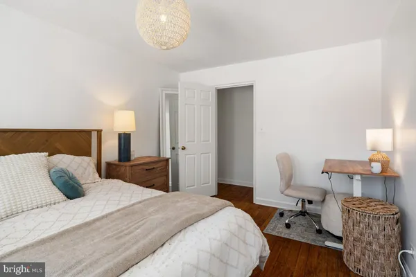 a bedroom with bed and chair with lamp
