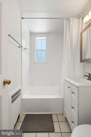 a bathroom with a bathtub a sink a toilet and a window