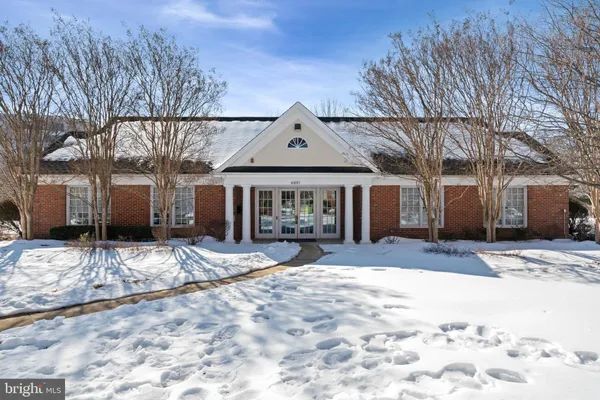 a front view of a house with a yard covered in snow