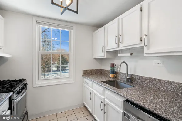 a kitchen with stainless steel appliances granite countertop a sink stove and cabinets