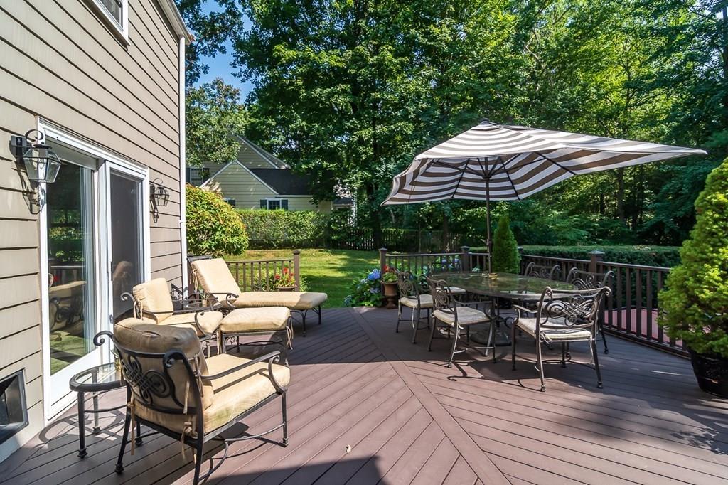 33 Tennyson Road Wellesley, MA 02481 - Photo 29 of 33 a view of a patio with a dining table and chairs under an umbrella with a small yard