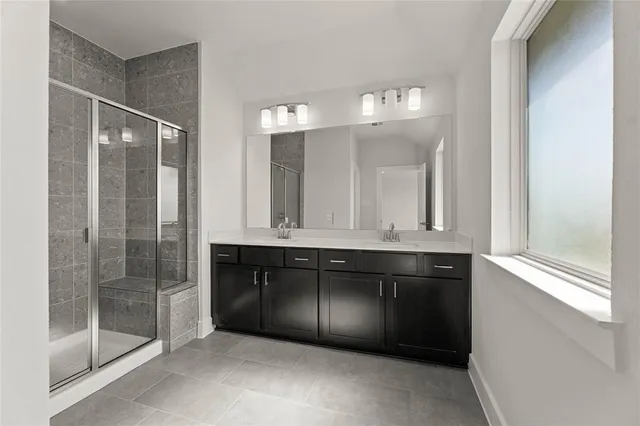 a bathroom with a granite countertop sink a mirror and a shower