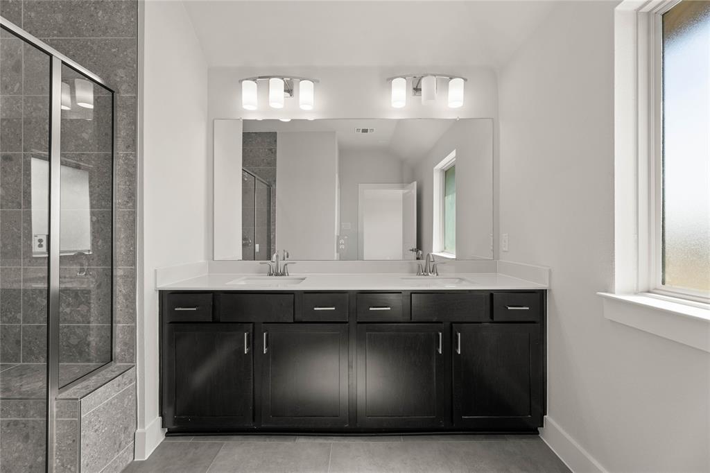 1610 Mint Road Argyle, TX 76226 - Photo 25 of 27 a bathroom with a granite countertop sink a mirror and a shower
