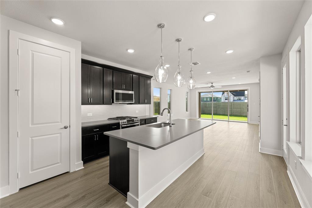 1610 Mint Road Argyle, TX 76226 - Photo 8 of 27 a kitchen with stainless steel appliances granite countertop a stove and a refrigerator