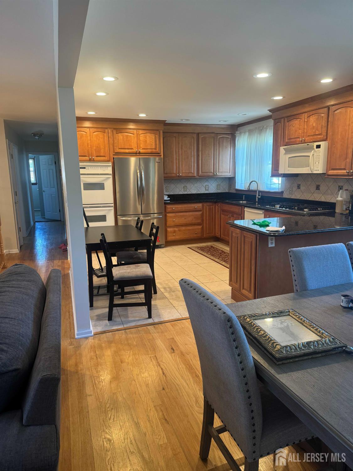 5 Timothy Court Edison, NJ 08837 - Photo 13 of 21 a kitchen with stainless steel appliances granite countertop a stove a sink a dining table and chairs