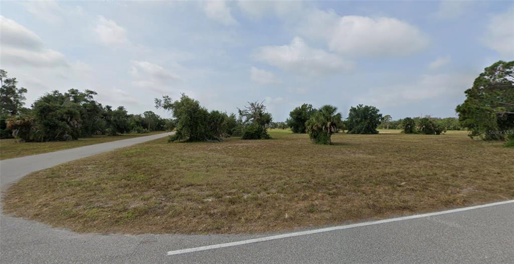 a view of a field with trees in background