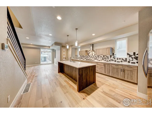 a large white kitchen with a large counter top and stainless steel appliances