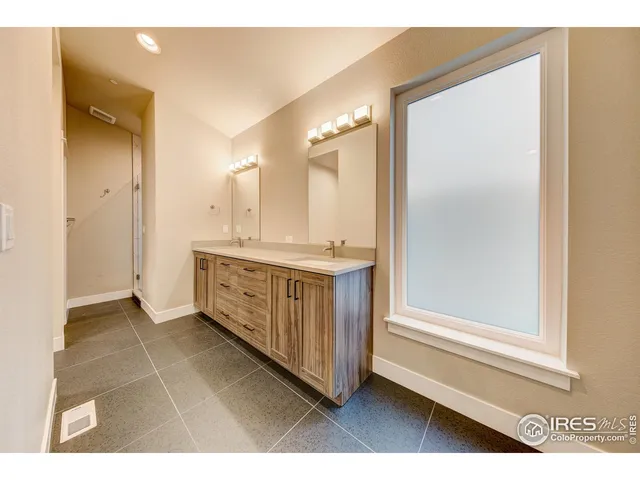 a bathroom with a double vanity sink and a mirror