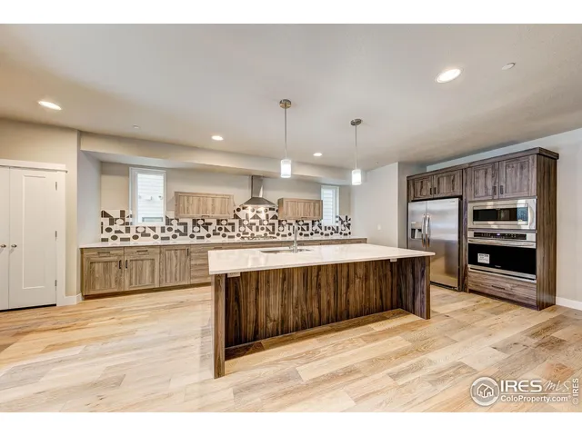 a kitchen with stainless steel appliances a kitchen island a stove and a sink