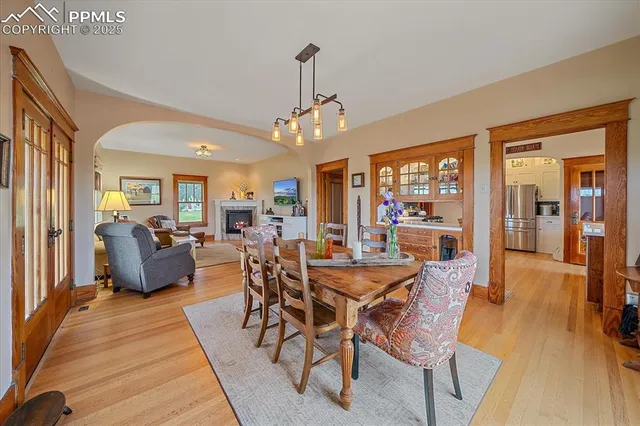 a view of a dining room and livingroom with furniture wooden floor a rug a flat screen tv a rug and a chandelier