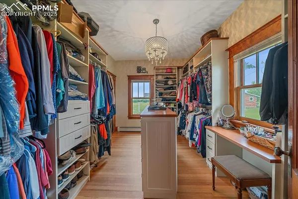 a view of walk in closet with clothes and shoes