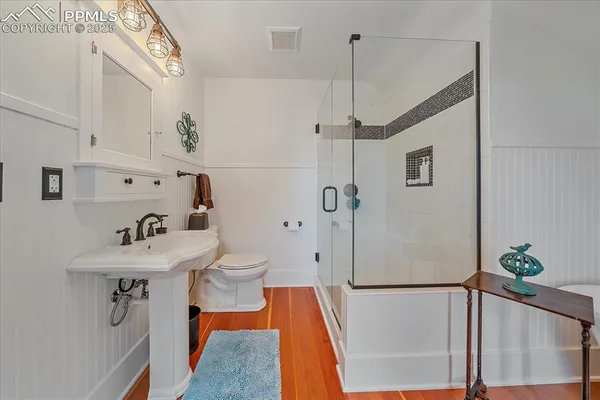 a bathroom with a sink a toilet and shower