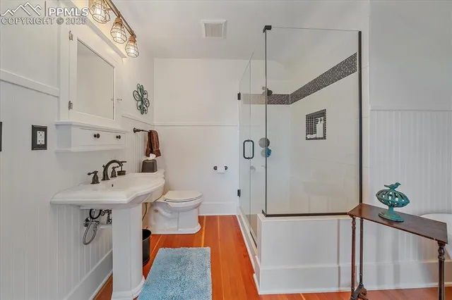 a bathroom with a sink a toilet and shower