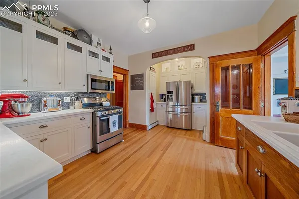 a kitchen with stainless steel appliances sink stove refrigerator and cabinets
