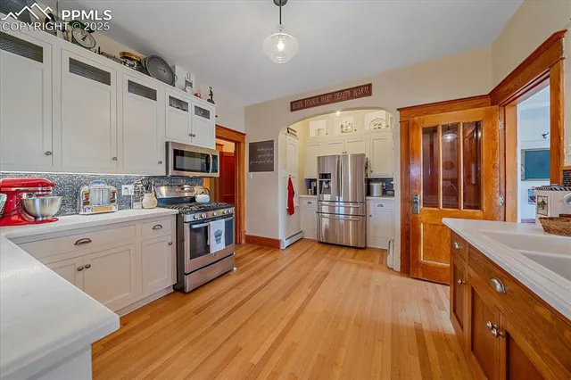 a kitchen with stainless steel appliances sink stove refrigerator and cabinets