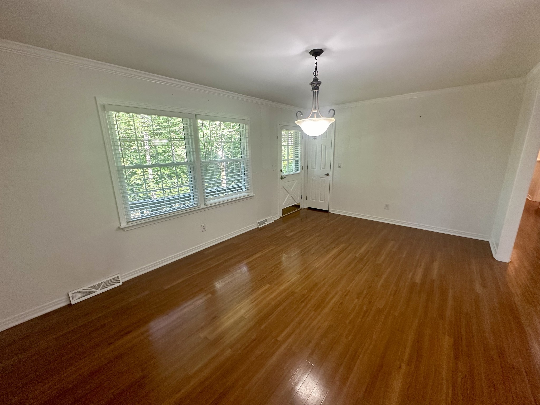 61 Nelson Road Lawrenceburg, TN 38464 - Photo 17 of 55 an empty room with wooden floor chandelier fan and windows