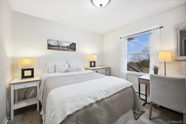 a bedroom with a bed and a lamp on dresser