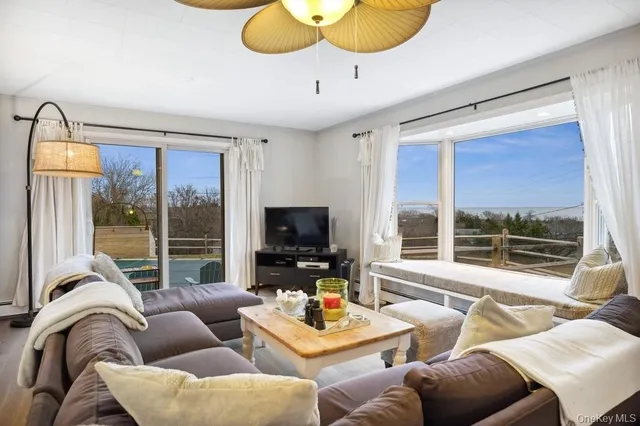 a living room with furniture a flat screen tv and a large window