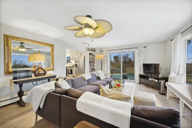 a living room with furniture a flat screen tv and a large window
