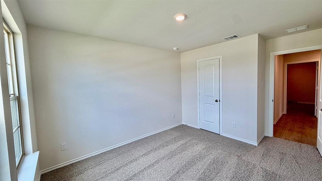 2003 Reveille Way Terrell, TX 75160 - Photo 21 of 25 Carpeted room featuring a white interior door, a single window, and recessed lighting