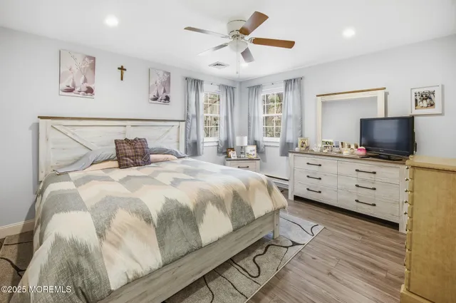 a bedroom with a bed and a flat tv screen on dresser