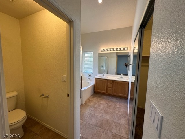 285 Spring Palms Street Henderson, NV 89012 - Photo 10 of 38 Full bathroom with a bath, an enclosed shower, tile patterned flooring, vanity, and toilet
