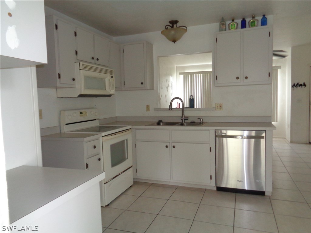 18538 Violet Road Fort Myers, FL 33967 - Photo 2 of 13 a kitchen with cabinets appliances a sink and a counter top space