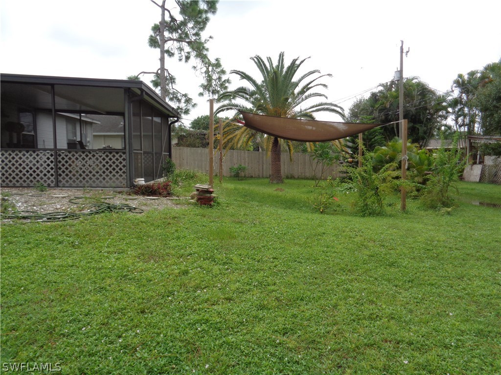 18538 Violet Road Fort Myers, FL 33967 - Photo 10 of 13 a backyard of a house with table and chairs potted plants and large tree