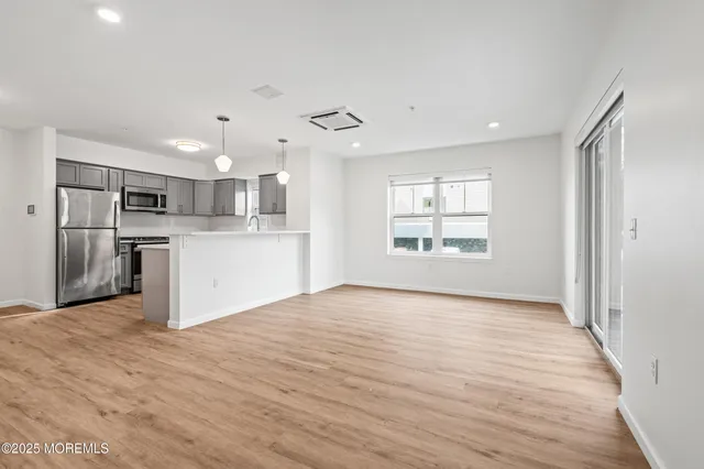 a view of a kitchen with a sink and dishwasher a refrigerator with wooden floor