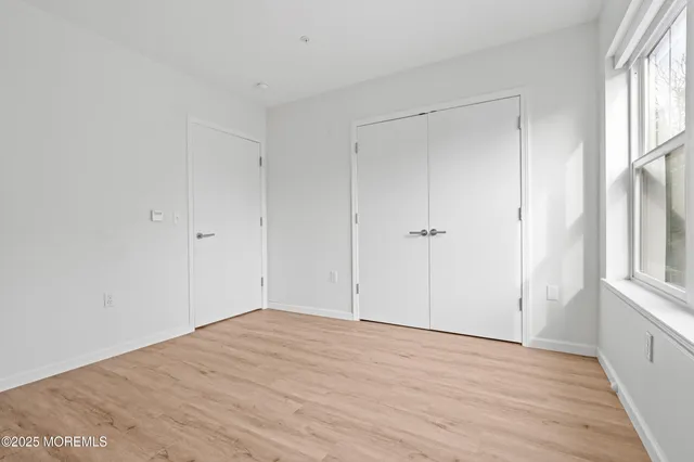 a view of empty room with wooden floor and cabinet