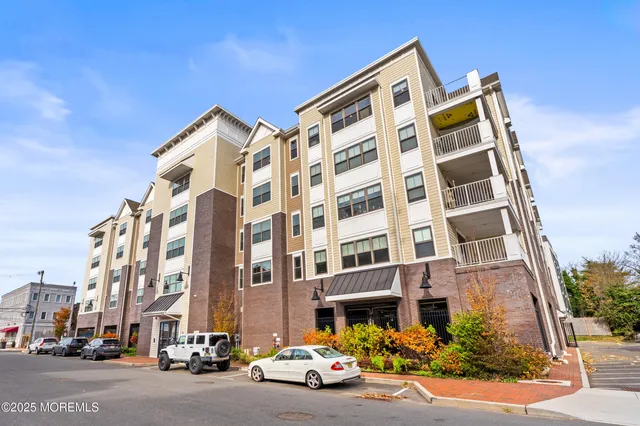 front view of a building with lot of cars and a parked car