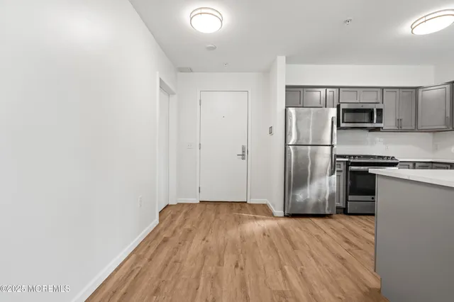 a kitchen with a refrigerator and a stove top oven