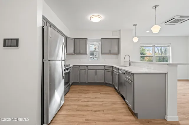 a kitchen with stainless steel appliances a sink and a refrigerator