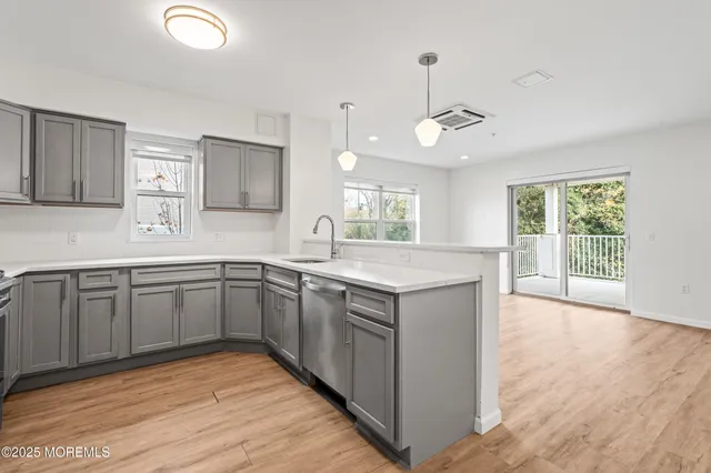 a kitchen with a sink cabinets and wooden floor