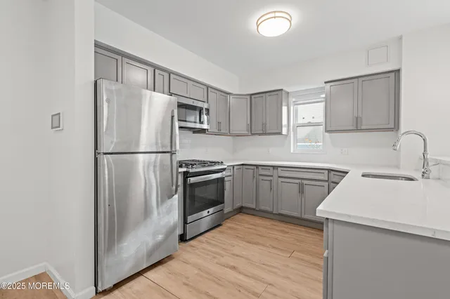 a kitchen with a refrigerator sink and cabinets