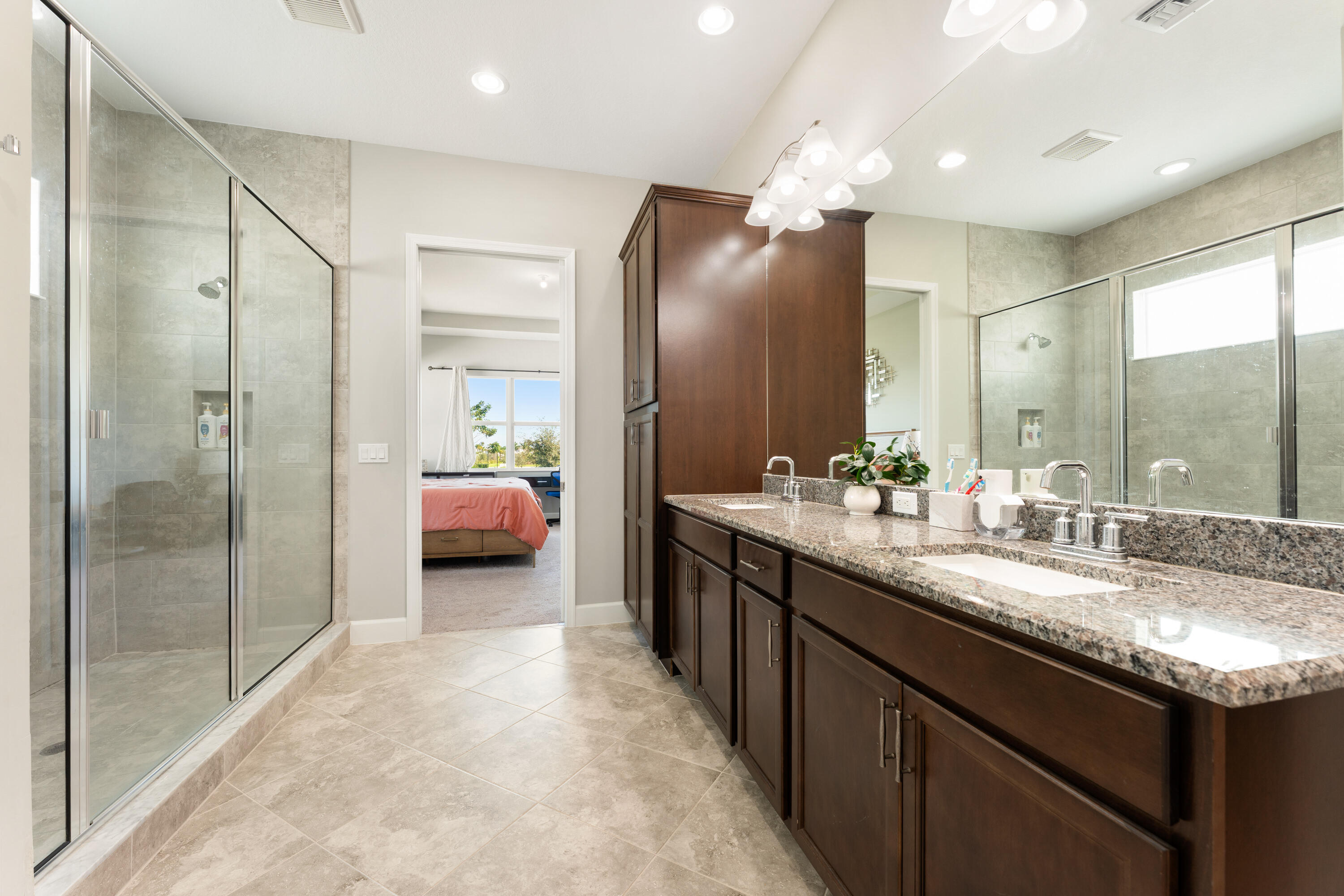 5446 Macoon Way Westlake, FL 33470 - Photo 16 of 40 a en suite bathroom with a granite countertop sink mirror and shower