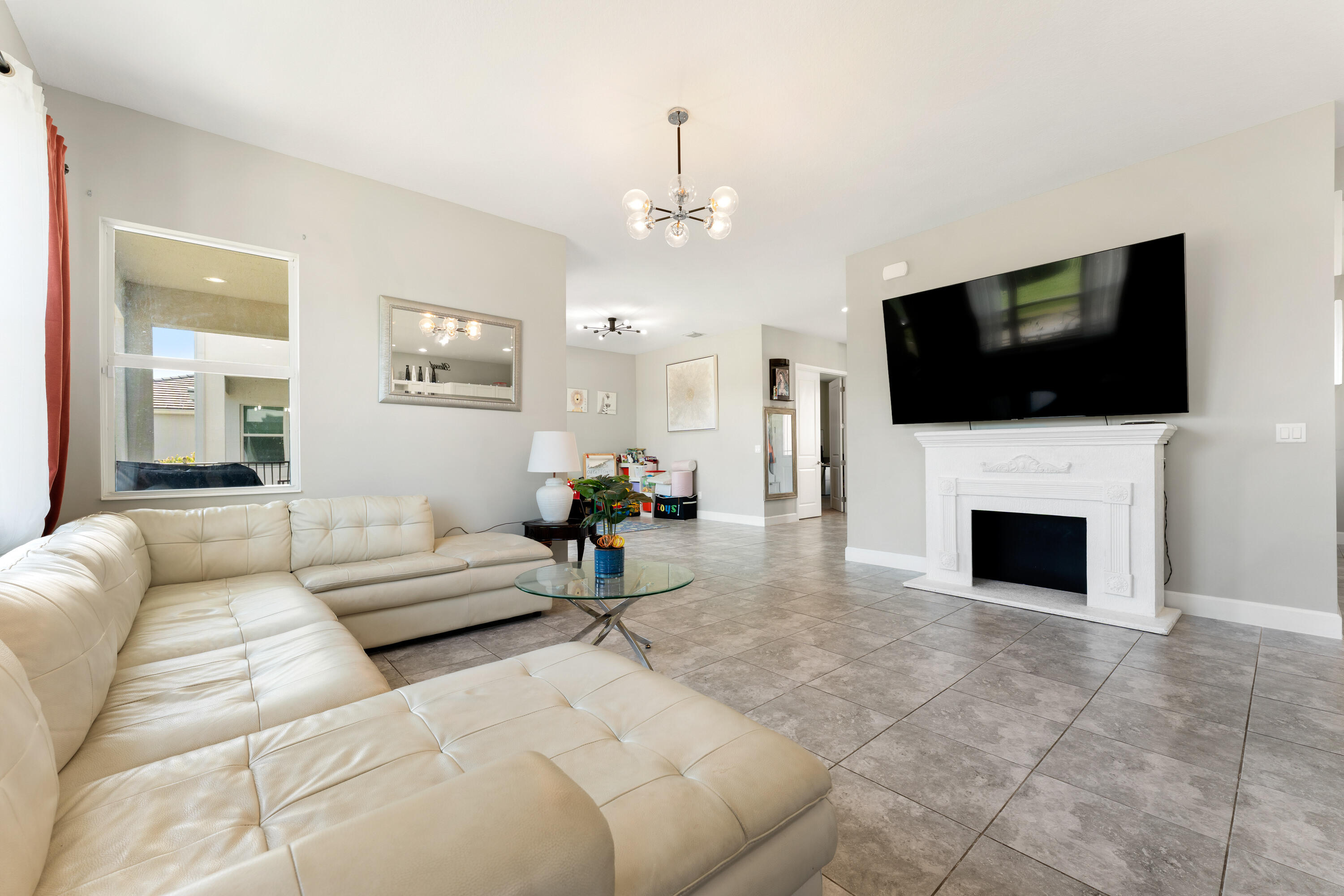 5446 Macoon Way Westlake, FL 33470 - Photo 5 of 40 a living room with furniture a flat screen tv and a fireplace