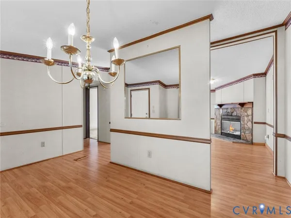 a view of a livingroom with wooden floor and a chandelier