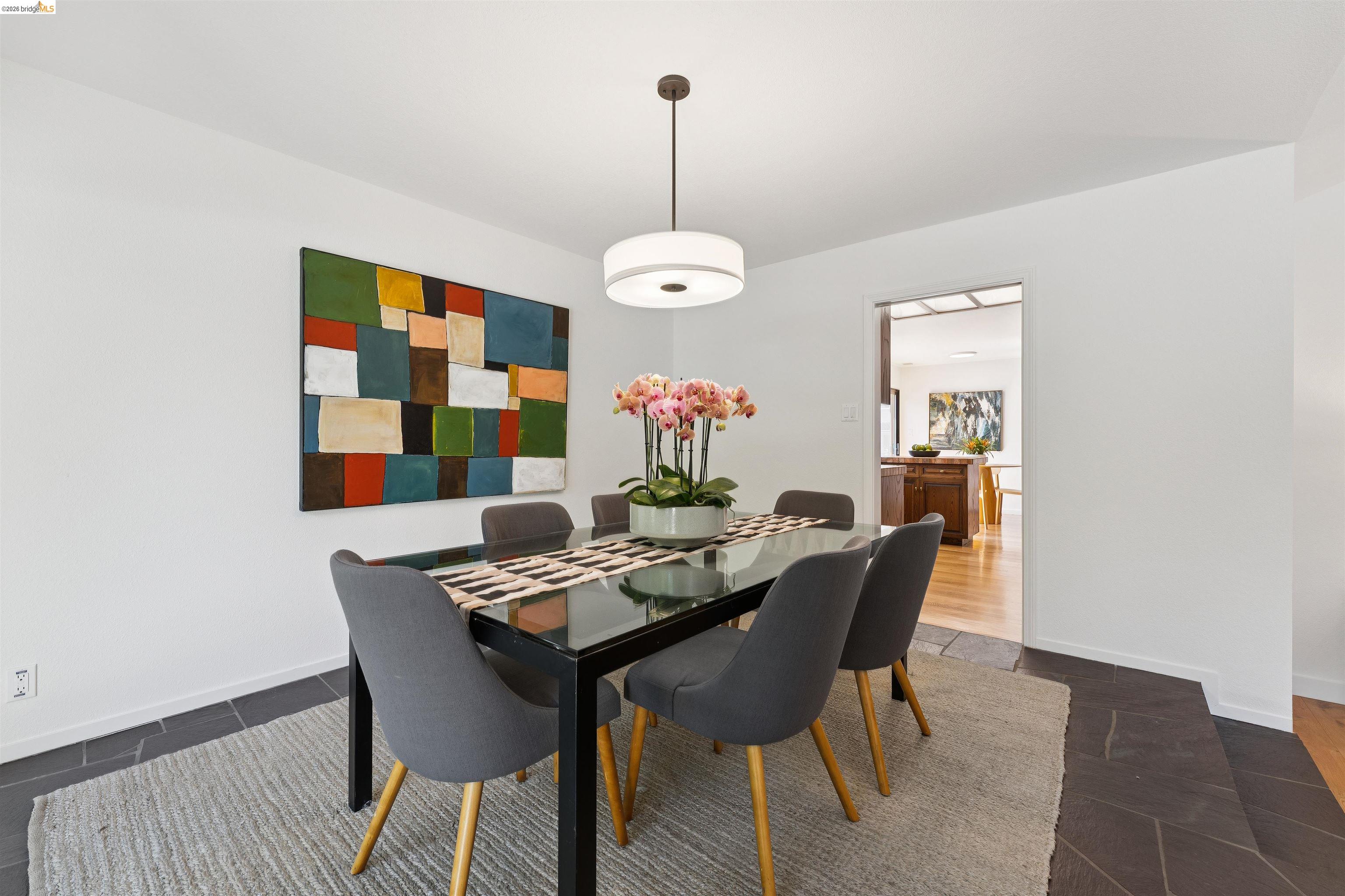 7 Jo Lin Court El Sobrante, CA 94803 - Photo 37 of 99 White walls and dark stone-look flooring enhance this dining space, featuring a modern ceiling light fixture